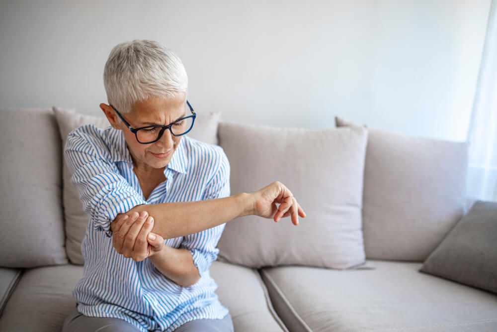 How do bone spurs develop in the elbow?